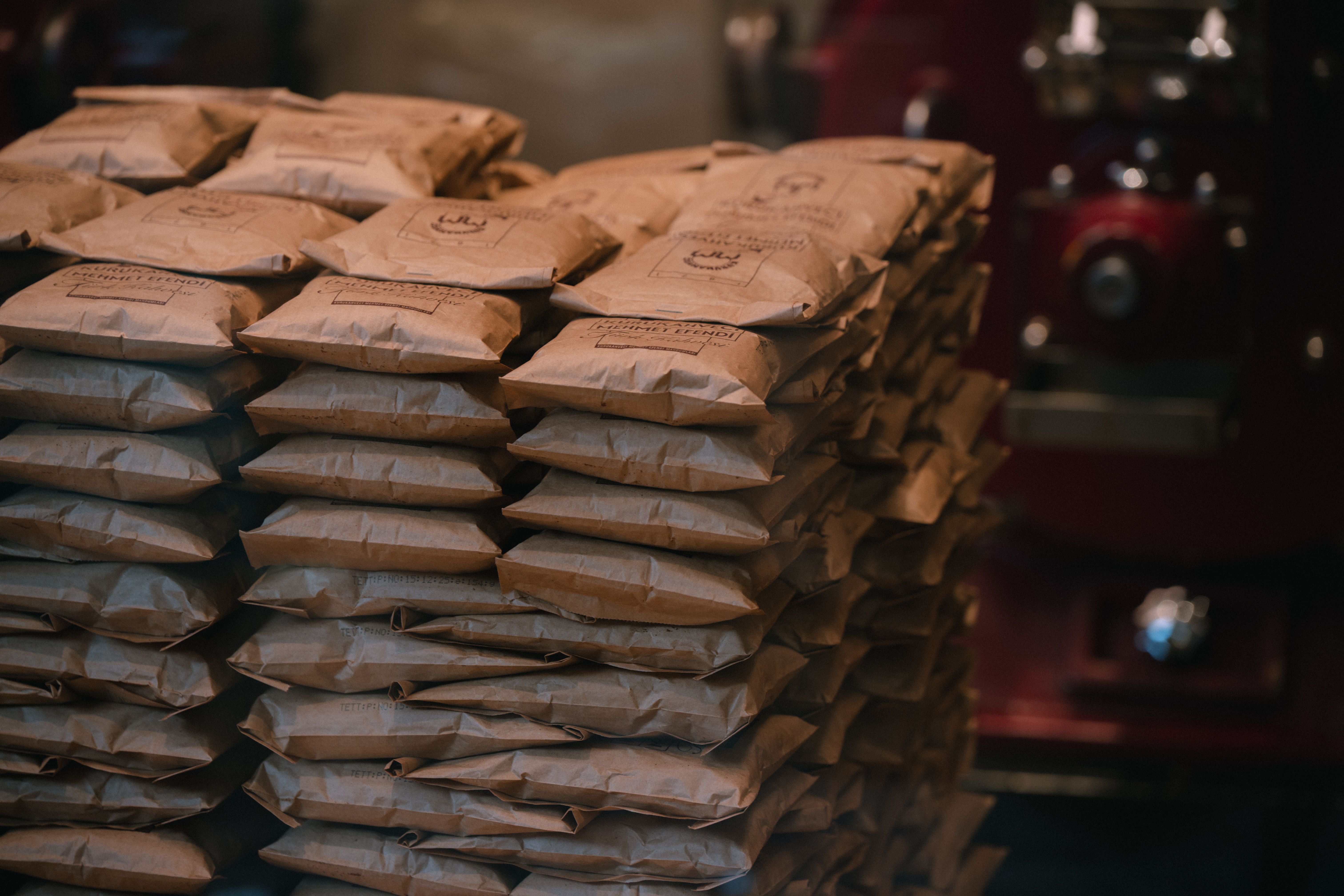 Stacked brown paper packages in an industrial warehouse, representing manufacturing scale and logistics