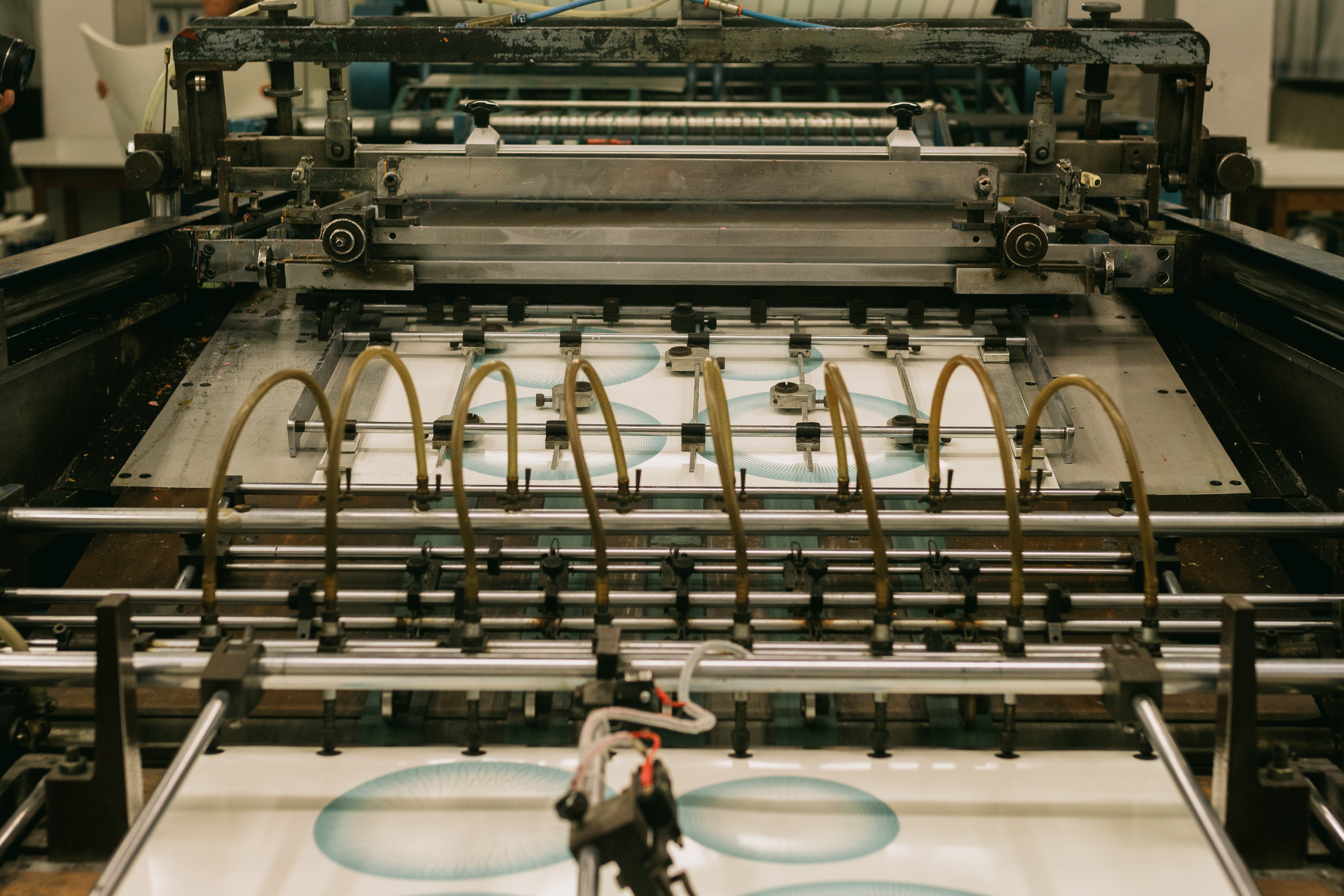 Close-up of an industrial printing press producing packaging designs in a manufacturing facility